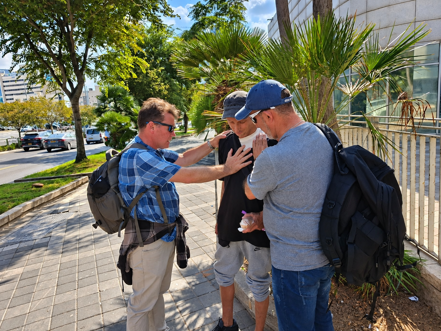 Elias Maron speaking with a man during Tel Aviv street outreach; the man's face is blurred